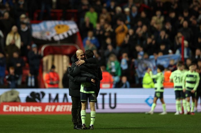 Pelatih Manchester City, Pep Guardiola, memeluk Bernardo Silva seusai laga ronde kelima Piala FA kontra Bristol City di Stadion Ashton Gate, Selasa (28/2/2023). Tim terbaik di Inggris ke 8 besar.