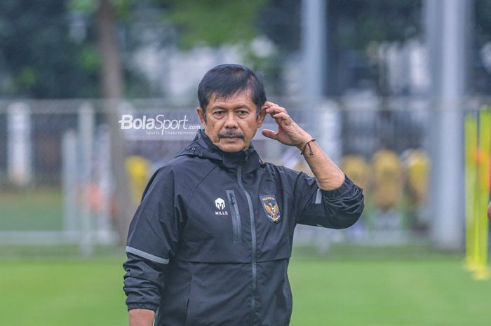 Pelatih timnas U-22 Indonesia, Indra Sjafri, sedang memegangi kepalanya sebagai tanda memikirkan strategi saat memantau timnya berlatih di Lapangan B, Senayan, Jakarta, Kamis (2/3/2023).