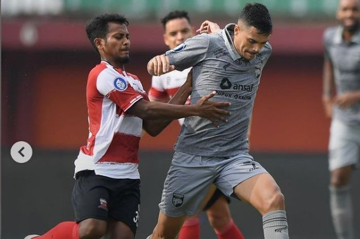 Zulfiandi dan Matheus Pato saat saling berduel di laga Madura United vs Borneo FC, Jumat (3/3/2023).