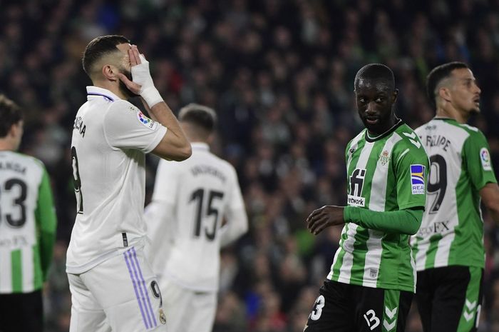 Striker Real Madrid, Karim Benzema, menutup wajah dalam laga Liga Spanyol kontra Real Betis di Stadion Benito Villamarin, Minggu (5/3/2023).