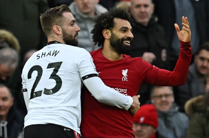 Bek kiri Manchester United, Luke Shaw, berduel dengan winger Liverpool, Mohamed Salah, dalam laga Liga Inggris di Stadion Anfield, Minggu (5/3/2023). Mo Salah jadi striker paling serakah di dunia.