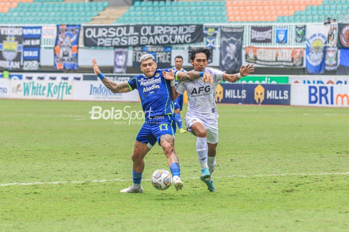 Striker Persib Bandung, Ciro Alves (kiri), sedang menguasai bola dan dibayangi pemain Persik Kediri bernama Yusuf Meilana Fuad Burhani (kanan) dalam laga pekan ke-29 Liga 1 2022 di Stadion Pakansari, Bogor, Jawa Barat, Rabu (8/3/2023).