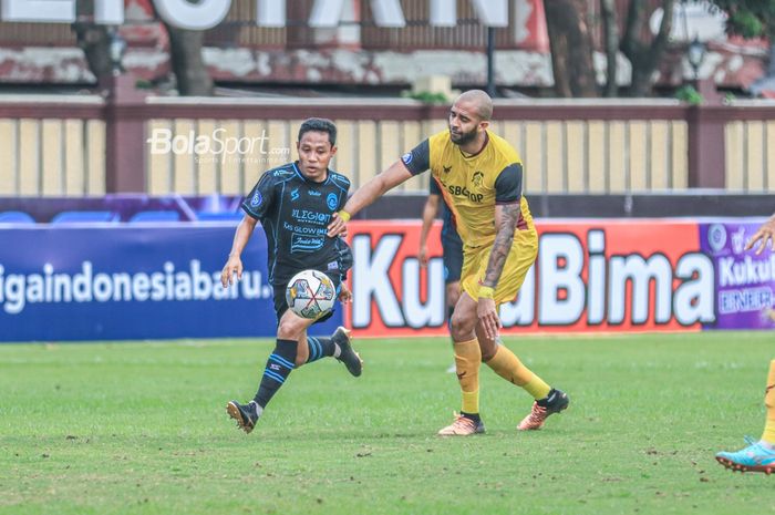 Pemain Arema FC, Evan Dimas (kiri), sedang menguasai bola dan dibayangi bek asing Persikabo 1973 bernama Lucas Gama Moreira alias Lucao (kanan) dalam laga pekan ke-31 Liga 1 2022 di Stadion PTIK, Blok M, Jakarta, Minggu (19/3/2023).