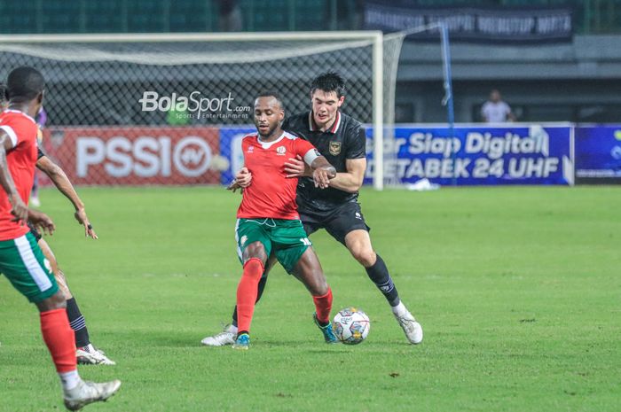 Striker timnas Burundi, Saido Berahino (depan), sedang menguasai bola dan dibayangi bek timnas Indonesia bernama Elkan Baggott (belakang) dalam laga kedua FIFA Matchday di Stadion Patriot Candrabhaga, Bekasi, Selasa (28/3/2023).