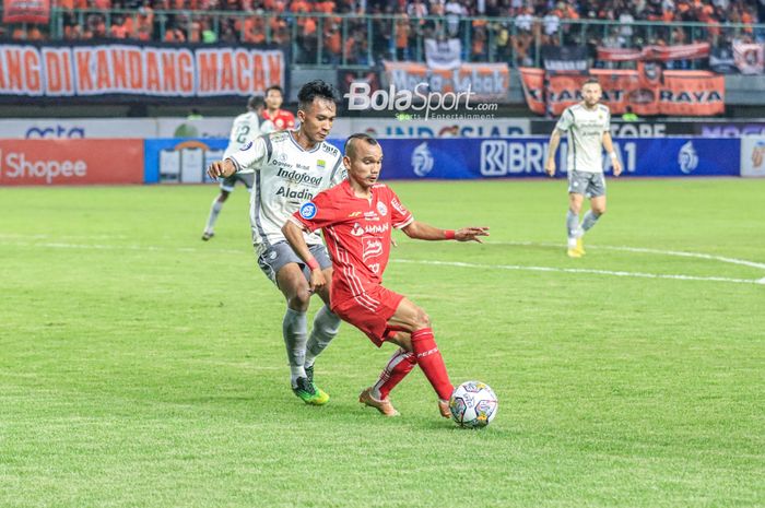 Riko Simanjuntak berduel dengan Robi Darwis pada laga Persija vs Persib di Stadion Patriot, Jumat (31/3/2023).