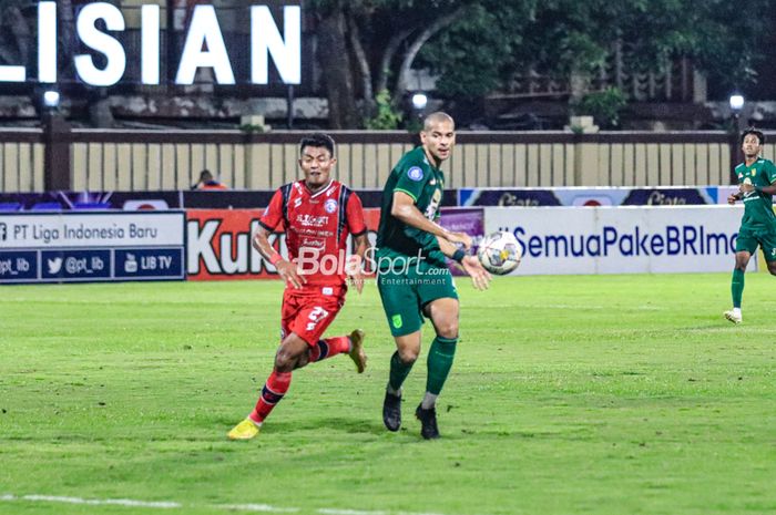 Bek asing Persebaya Surabaya, Leonardo Silva Lelis alias Leo Lelis (kanan), sedng mengamankan bola dari jangkauan striker Arema FC bernama Dedik Setiawan (kiri) dalam laga tunda pekan ke-28 Liga 1 2022 di Stadion PTIK, Blok M, Jakarta, Selasa (11/4/2023) malam.