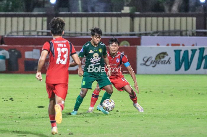 Pemain Persebaya Surabaya, Mochamad Supriadi (kiri), sedang menguasai bola dan dibayangi bek Arema FC bernama Johan Alfarizie (kanan) dalam laga tunda pekan ke-28 Liga 1 2022 di Stadion PTIK, Blok M, Jakarta, Selasa (11/4/2023) malam.