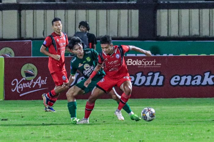 Pemain Arema FC, Achmad Figo Ramadani (kanan), sedang menguasai bola dan dibayangi pilar Persebaya Surabaya bernama Muhammad Iqbal (tengah) dalam laga tunda pekan ke-28 Liga 1 2022 di Stadion PTIK, Blok M, Jakarta, Selasa (11/4/2023) malam.