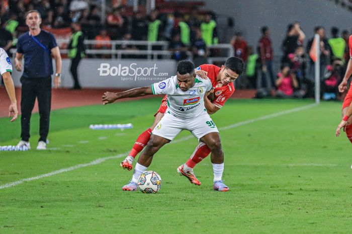 Penyerang PSS Sleman, Ricky Cawor (depan), sedang menguasai bola dan berusaha direbut pemain Persija Jakarta bernama Ilham Rio Fahmi  (belakang) dalam laga pekan ke-34 Liga 1 2022 di Stadion Utama Gelora Bung Karno, Senayan, Jakarta, Sabtu (15/4/2023) malam.