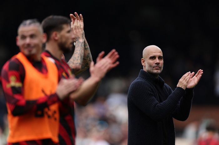 Pep Guardiola (kanan) membawa Manchester City memuncaki klasemen sementara Liga Inggris dan menggusur Arsenal usai menekuk Fulham di Craven Cottage (30/4/2023).