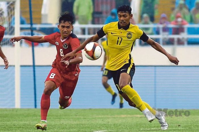 Pemain Timnas Malaysia, Muhammad Safwan Mazlan, dibayangi oleh pemain Timnas Indonesia Witan Sulaeman pada pertandingan perebutan medali perunggu SEA Games 2021 di Hanoi, Vietnam.