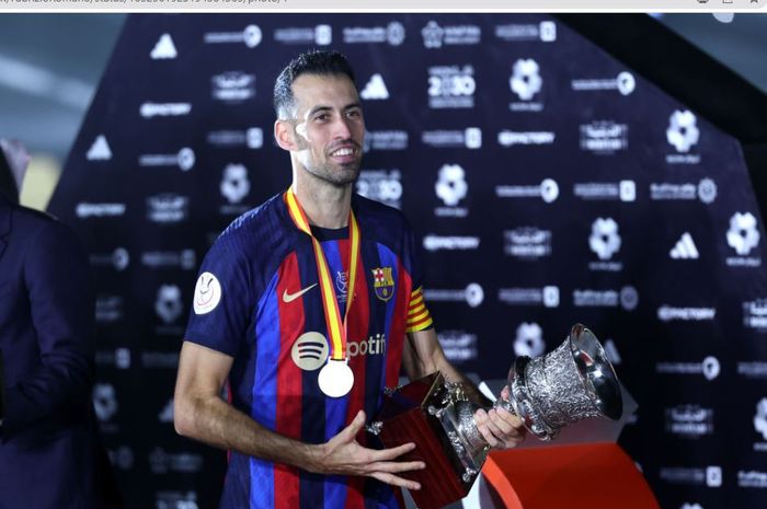 Sergio Busquets saat meraih trofi Piala Super Spanyol 2022-2023 untuk Barcelona.