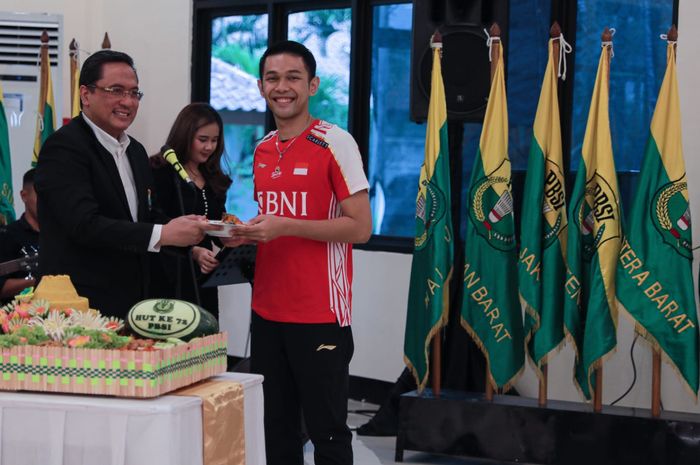 Pebulu tangkis ganda putra Indonesia, Fajar Alfian, menerima secara simbolis potongan tumpeng dari Ketua Umum PP PBSI Agung Firman Sampurna di sela pengukuhan Sudirman Cup 2023 di pelatnas Cipayung, Jakarta Timur, Senin (8/5/2023).