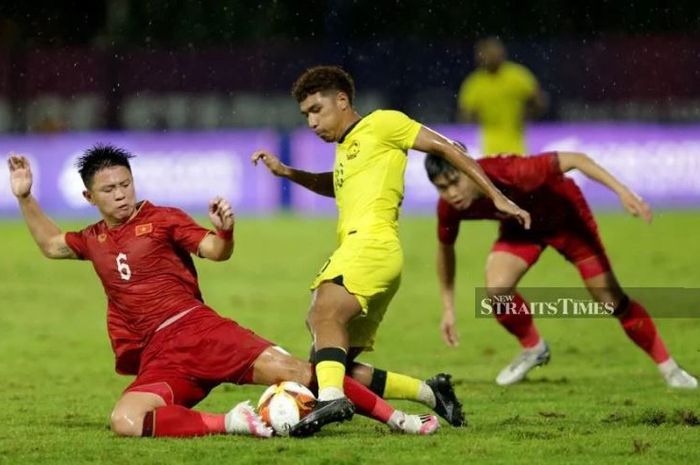 Pemain Timnas U-22 Malaysia Aliff Izwan Yuslan (tengah) berebut bola dengan dua pemain Vietnam pada pertandingan Grup B SEA Games 2023.