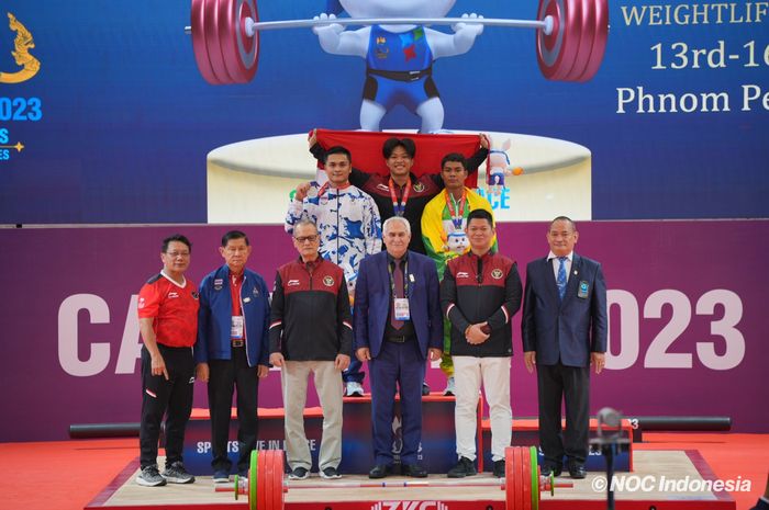 Lifter putra Indonesia, Rahmat Erwin Abdullah, di podium juara usai meraih emas kelas 81 kg pada SEA Games 2023 di Olympic Complex: Taekwondo Hall, Phnom Penh, Senin (15/5/2023).