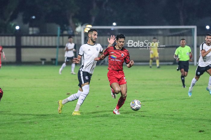 Striker Persija Jakarta, Aji Kusuma (kanan), sedang menggiring bola dan dijaga bek asing RANS Nusantara FC bernama Francisco Carneiro Kiko (kiri) dalam laga uji coba di Stadion PTIK, Blok M, Jakarta, Rabu (21/6/2023) malam.