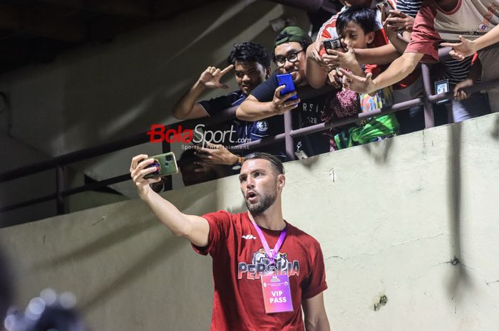 Striker asing pemain Persija Jakarta, Marko Simic (depan), sedang berfoto selfie dengan sejumlah The Jakmania (suporter Persija) di Stadion PTIK, Blok M, Jakarta, Rabu (21/6/2023) malam.