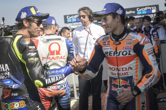 Valentino Rossi dan Marc Marquez berjabat tangan setelah kualifikasi MotoGP Inggris di Sirkuit Silverstone, Inggris, 24 Agustus 2019.