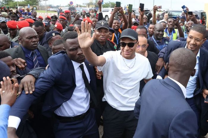 Kylian Mbappe melambaikan tangan kepada fans di luar Bandara Yaounde di Yaounde, Kamerun, Kamis, 6 Juli 2023, dalam kunjungan amal ke kampung halaman ayahnya.