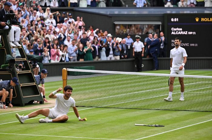 Petenis Spanyol, Carlos Alcaraz (kiri), merayakan kemenangannya atas Novak Djokovic dari Serbia pada final tunggal putra Wimbledon 2023 di The All England Tennis Club, London, Inggris, 16 Juli 2023.