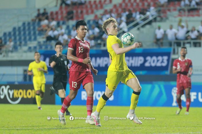 Pemain Malaysia, Fergus Tierney (kanan), saat berduel dengan bek Timnas U-23 Indonesia, Kadek Arel (kiri).