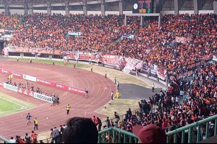 Sejumlah suporter yang melempar air mineral dalam bungkus plastik. Mereka melempar ke arah lapangan tepat setelah peluit panjang ditiup wasit tanda laga antara Persija Jakarta vs Persib Bandung di Stadion Patriot Candrabhaga, Bekasi berakhir.