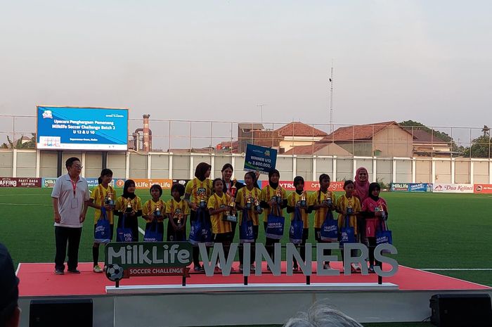 Para pemain sepak bola wanita usia 12 tahun menerima penghargaan juara kelompok usia U-12 dalam turnamen MilkLife Soccer Challenge, SD 2 Rendeng, Kudus, Jawa Tengah, Minggu (3/9/2023).