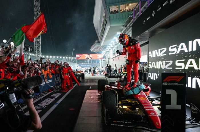 Pembalap Ferrari, Carlos Sainz merayakan kemenangan usai menjuarai seri F1 GP Singapura 2023, Minggu (17/9/2023)