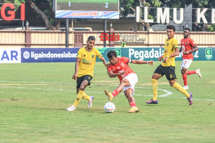 Ilham Udin Armaiyn (tengah) sedang menendang bola dan dibayangi dua pemain Perserang Serang bernama Aljufri Daud (kiri) dan Dede Komarudin (kanan) dalam laga Liga 2 2023 di Stadion PTIK, Blok M, Jakarta, Senin (18/9/2023).