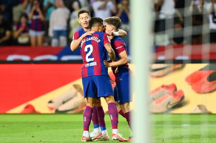 Robert Lewandowski, Gavi, dan Joao Cancelo saling berpelukan setelah Barcelona menang dramatis atas Celta Vigo  via comeback dengan skor 3-2.