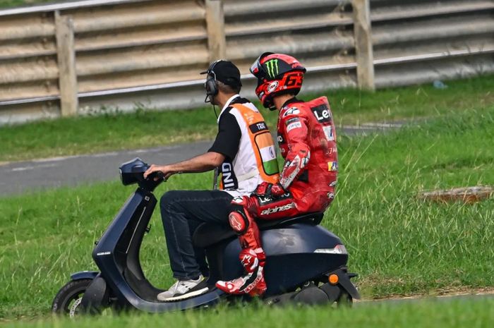 Pembalap Ducati Lenovo, Francesco Bagnaia diantar skuter menuju paddock setelah balapannya di MotoGP India 2023 tamat lebih cepat akibat kecelakaan di Sirkuit Buddh, India, MInggu (24/9/2023)