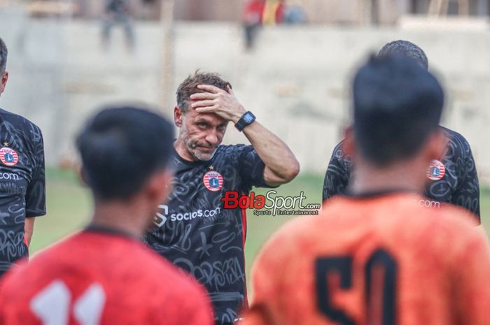 Pelatih Persija Jakarta, Thomas Doll, sempat memegangi kepalanya saat memberikan intruksi kepada para pemainnya saat berlatih di Lapangan Nirwana Park, Sawangan, Jawa Barat, Rabu (4/10/2023).