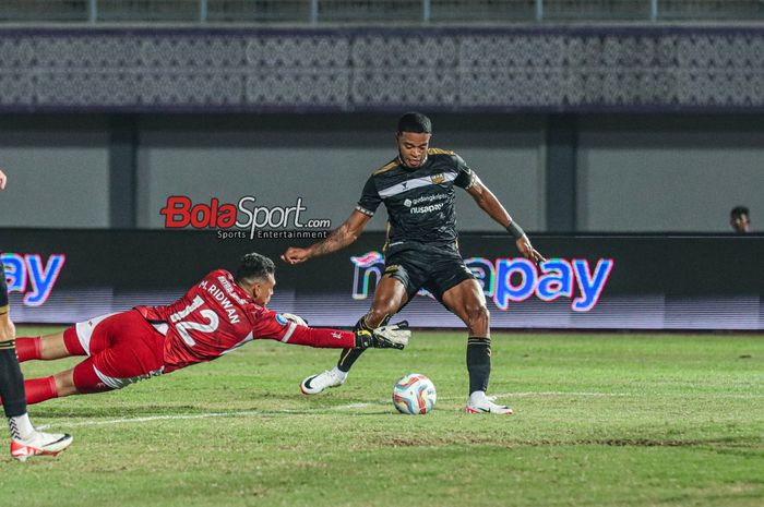 Striker asing Dewa United, Alex Martins (kanan), akan menendang bola dan coba dihalau kiper PSS Sleman bernama Muhammad Ridwan (kiri) dalam laga pekan ke-15 Liga 1 2023 di Stadion Indomilk Arena, Tangerang, Banten, Jumat (6/10/2023) malam.