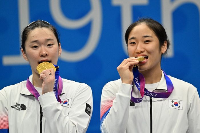 Tunggal putri Korea Selatan, An Se-young (kanan) and Kim Ga-eun, merayakan medali emas yang mereka menangi dari nomor bulu tangkis beregu putri Asian Games 2022 di Hangzhou, China, 1 Oktober 2023.