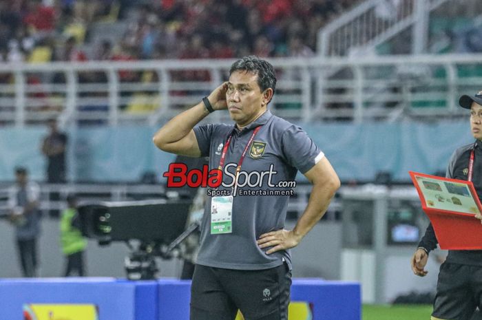 Pelatih timnas U-17 Indonesia, Bima Sakti, sempat memegangi kepalanya saat memantau para pemainnya bertanding di Stadion Gelora Bung Tomo, Surabaya, Jawa Timur, Senin (13/11/2023).