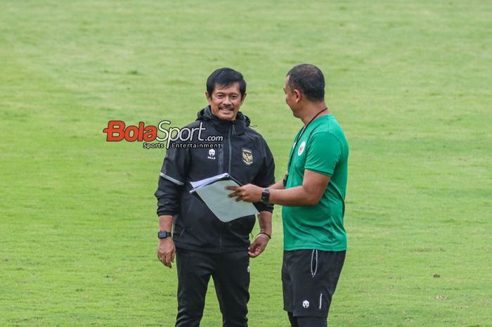 Pelatih timnas U-20 Indonesia, Indra Sjafri (kanan), sedang berdiskusi dengan salah satu asistennya saat memantau latihan di Lapangan A, Senayan, Jakarta, Jumat (9/2/2024).