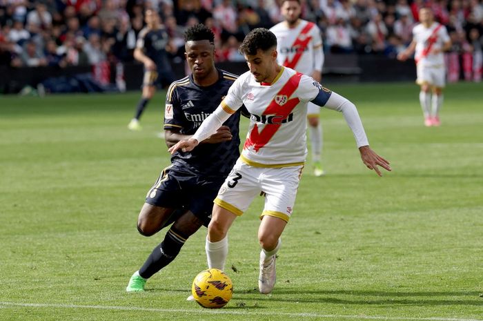 Vinicius Jr berebut bola dengan Oscar Valentin dalam lawatan Real Madrid ke markas Rayo Vallecano, Stadion Vallecas, pada lanjutan Liga Spanyol (18/2/2024).