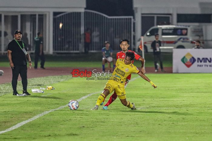Firman Juliansyah (depan) sedang berebut bola dengan Mohammad Bagus Nirwanto (belakang) dalam laga leg pertama semifinal Liga 2 2023 antara Malut United FC versus Semen Padang FC di Stadion Madya, Senayan, Jakarta, Minggu (25/2/2024) malam.