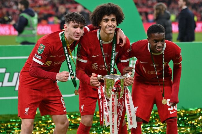 Tiga pemain muda Liverpool, Lewis Koumas (kiri), Jayden Danns (tengah), dan Treymaurice Nyoni berpose dengan trofi Piala Liga Inggris usai kalahkan Chelsea di Wembley (25/2/2024).