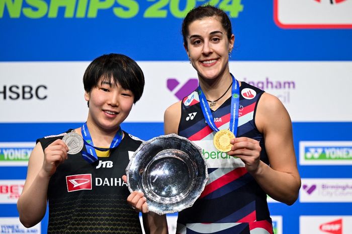 Runner-up tunggal putri Akane Yamaguchi (kiri) dari Jepang dan sang juara Carolina Marin (kanan) dari Spanyol berpose di atas podium setelah bertanding di final All England Open 2024 di Utilita Arena di Birmingham, Inggris, pada 17 Maret 2024. 