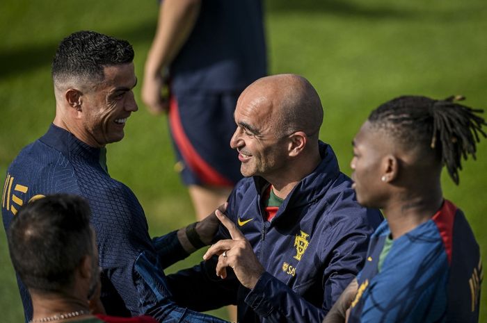 Cristiano Ronaldo (kiri) berbicara bersama pelatih Roberto Martinez dalam sesi latihan timnas Portugal (13/6/2023).