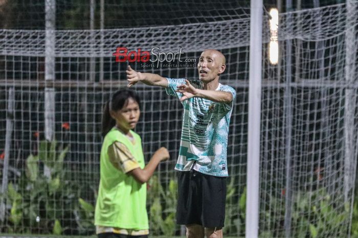 Pelatih timnas wanita U-17 Indonesia, Satoru Mochizuki, sedang memberikan intruksi kepada para pemainnya di Lapangan B, Senayan, Jakarta, Jumat (5/4/2024) malam.