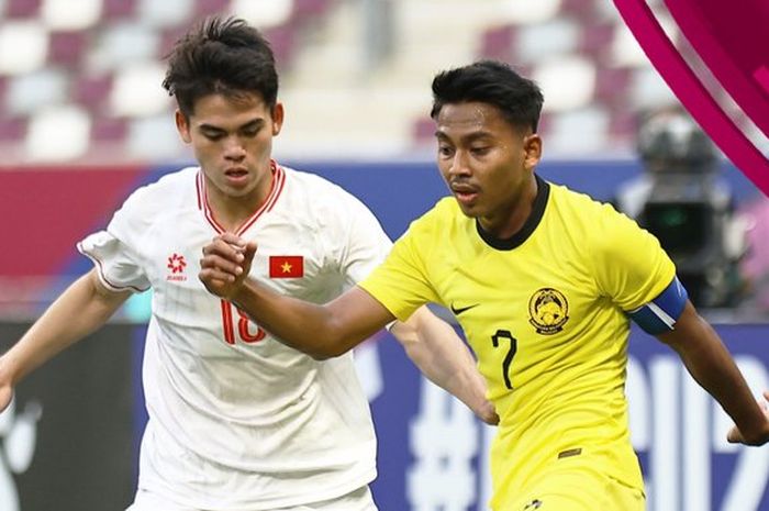Kapten Timnas U-23 Malaysia, Mukhairi Ajmal Mahadi (kanan), mendapat pengawalan dari pemain Vietnam Khuat Van Khang.