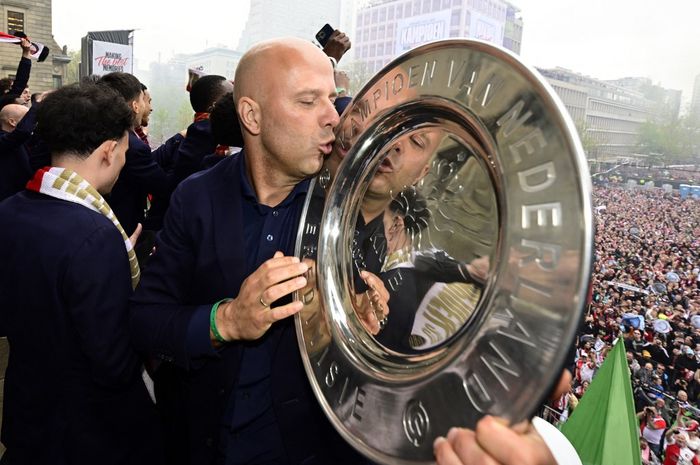 Arne Slot berpose dengan piringan gelar Liga Belanda untuk Feyenoord di jalanan Rotterdam (15/5/2023).