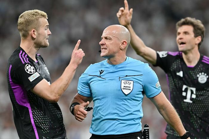 De Ligt (kiri) berdebat dengan wasit Polandia Szymon Marciniak dalam laga leg kedua semifinal Liga Champions antara Bayern Muenchen dan Real Madrid di Stadion Bernabeu.