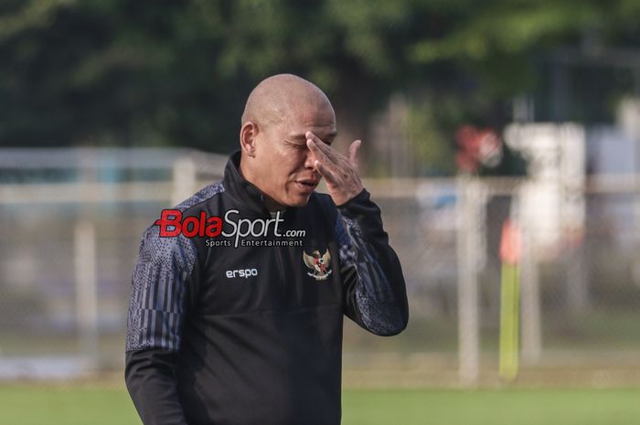 Pelatih Timnas U-17 Indonesia, Nova Arianto, sempat memegangi wajah saat memantau para pemainnya berlatih di Lapangan B, Senayan, Jakarta, Kamis (8/8/2024).