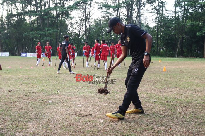 Salah satu official timnas amputasi Indonesia sedang menambal lapangan yang berlubang saat sesi latihan di Lapangan Pamentas, Lebak Bulus, Jakarta, Selasa (20/8/2024).