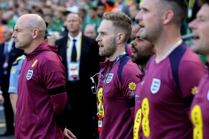 Pelatih interim Timnas Inggris, Lee Carsley (kiri), hanya mendengarkan tetapi tidak ikut menyanyikan lagu kebangsaan dalam laga UEFA Nations League melawan Irlandia, Sabtu (7/9/2024) di Dublin.