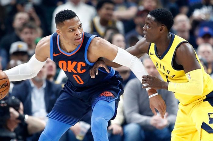 Pemain bintang Oklahoma City Thunder, Russell Westbrook (jersey biru, #0), mendribel bola seraya dijaga oleh pemain Indiana Pacers, Darren Collison, saat menjalani laga musim reguler NBA 2017-2018 di Bankers Life Fieldhouse, Indianapolis, Indiana, Rabu (13/12/2017).