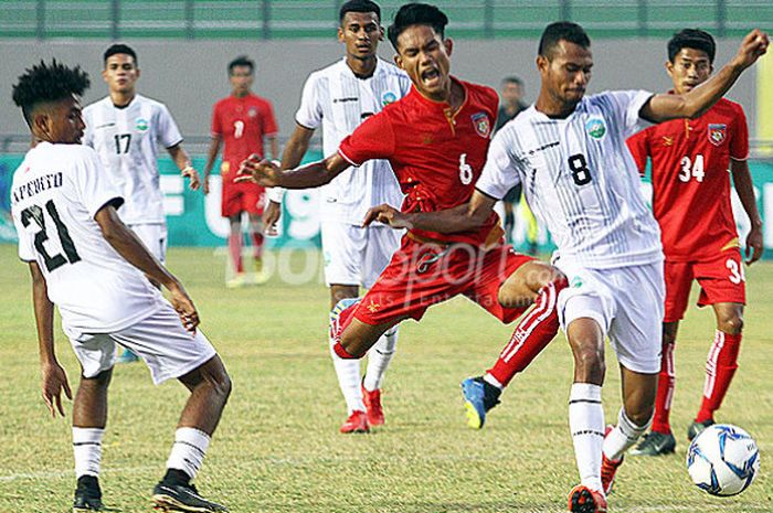 Pemain Timor Leste, Filomeno J Da Costa (putih/8) berusaha melindungi bola dari pemain Myanmar pada laga Grup B Piala AFF U-19 2018 di Stadion Gelora Joko Samudro Gresik, Senin (2/7/2018).